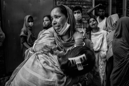Grief-stricken family members wail beside the Hashem Foods ltd, Fire broke out in the six story building on July 08, 2021 evening, which left at least 52 dead while many are still missing.